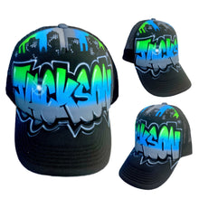 Load image into Gallery viewer, A custom airbrushed trucker cap with a geometric pattern in blue and green on a black background, with an adjustable snapback clip at the back.